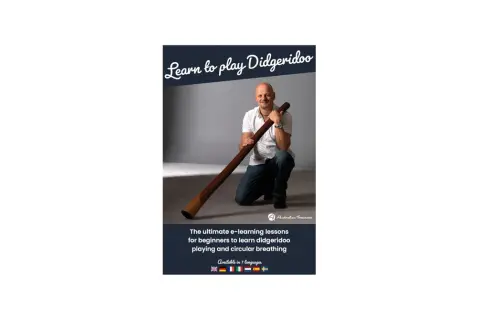 Mann kniet mit einem Didgeridoo, bereit, es zu spielen. Online-Kurse für Anfänger.