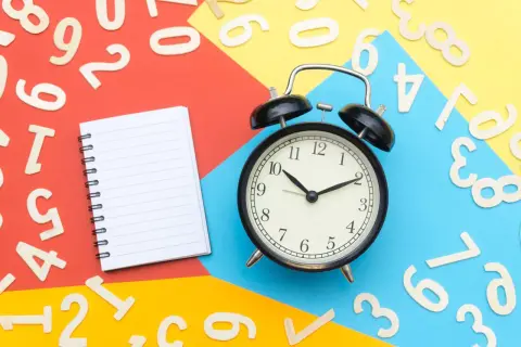 Sulla scrivania, numeri sparsi, un quaderno e una sveglia indicano che si può cambiare assicurazione prima della scadenza annuale.
