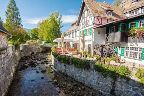 Urokliwy deptak w Szklarskiej Porębie nad górskim potokiem. Restauracja z ogródkiem i zielonymi okiennicami.