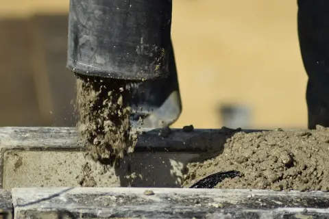 Beton wylewany z rury, rozpoczyna się proces wiązania. Czas, ile schnie suchy beton, zależy od wielu czynników.