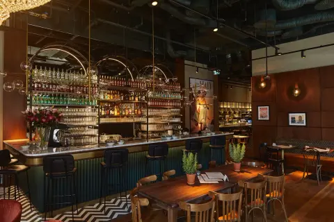 Elegancki bar z mnóstwem butelek alkoholu i kieliszków, idealne miejsce na odkrywanie ciekawych restauracji w Warszawie.