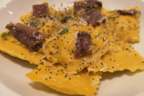 Ravioli gialli con acciughe e semi di papavero, un piatto da provare alla trattoria da me Bologna.