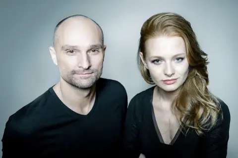 Dominik Strzelec i jego żona, uśmiechnięci, patrzą w obiektyw.
