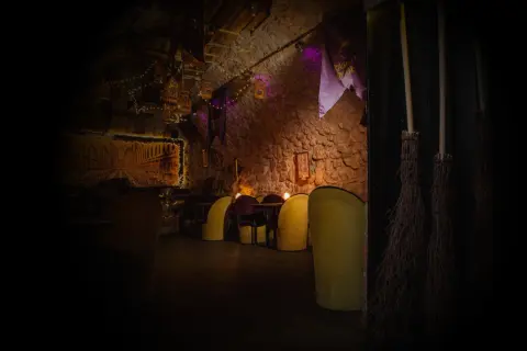 Magiczne wnętrze, jak z muzeum Harry Potter w Krakowie. Miękkie fotele, kamienne ściany i miotły czekają na czarodziejów.