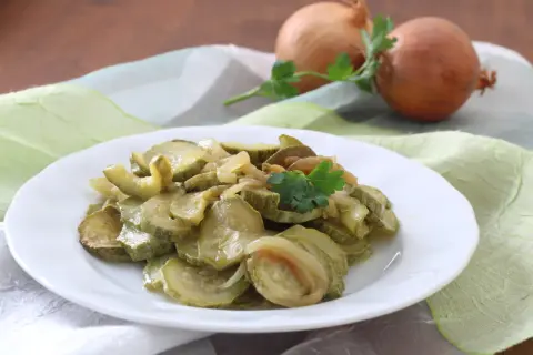 Zucchine in padella con cipolla, un contorno semplice e gustoso, guarnito con prezzemolo fresco.