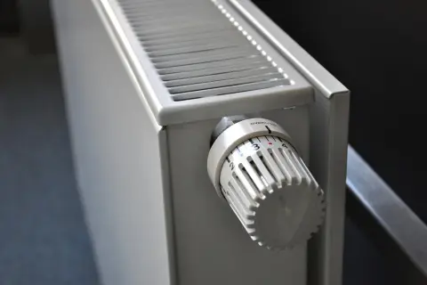 Biały grzejnik z termostatem, idealny do ogrzewania etażowego. Ustaw temperaturę na komfortowy poziom.