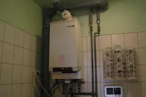 Kocioł gazowy Broetje, który pokazuje, jak ogrzewane są bloki. Obok wiszą uchwyty na papier toaletowy.
