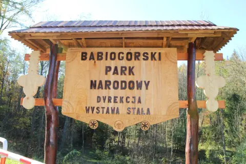 Drewniana tablica informacyjna Babiogórskiego Parku Narodowego. Zapowiada liczne zawoja atrakcje i wystawę stałą.
