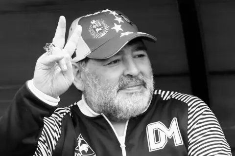 Diego Maradona, w czapce z gwiazdami, pokazuje znak pokoju. Ile lat ma Maradona? To pytanie zadaje sobie wielu fanów.