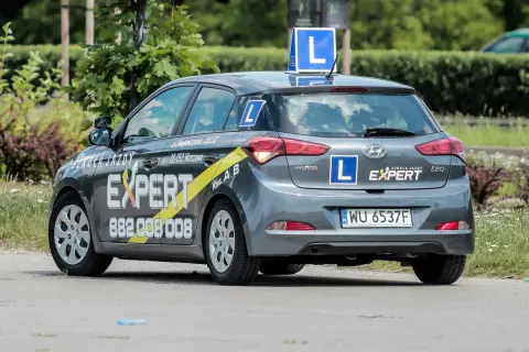 Szara Skoda z literą "L" na dachu i bokach, oznakowana jako "Szkoła Jazdy EXPERT". Tu dowiesz się, gdzie wyrobić profil kierowcy.