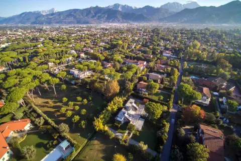 Vaste aree verdi con ville moderne e tradizionali, pini marittimi e montagne sullo sfondo. È un buon momento per comprare casa in questo paradiso.