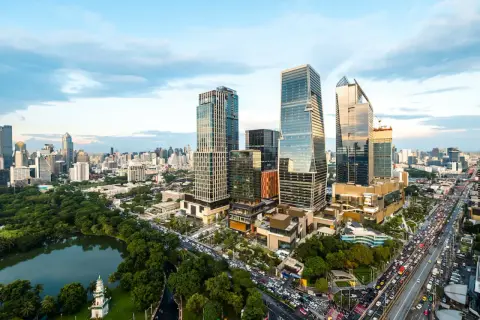 En livlig stadssilhuett i Thonglor, Bangkok, med höga skyskrapor, grönskande parker och en trafikerad motorväg.