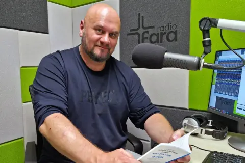 Arkadiusz Łodziewski w studiu Radia Fara, trzymający książkę. Jego życiorys mógłby opowiadać o tej chwili.