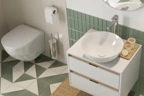 Nowoczesna łazienka z białym, wiszącym wc w rogu, umywalką nablatową i zielonymi płytkami.