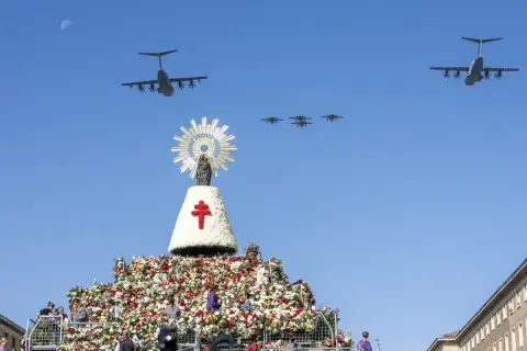Desfile aéreo de aviones militares sobre una gran ofrenda floral y una imagen de la Virgen del Pilar, celebrando las fiestas del Pilar.