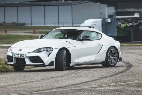 Biała Toyota GR Supra na torze, zostawiająca ślady opon.
