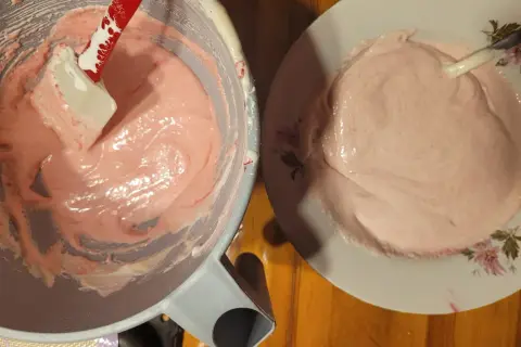 Różowa masa na makaroniki francuskie w misce i na talerzyku.
