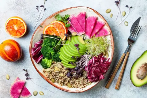 Piatto colorato con quinoa, broccoli, avocado, ravanelli, arance rosse e germogli. Ideale per una dieta priva di scorie cosa mangiare.