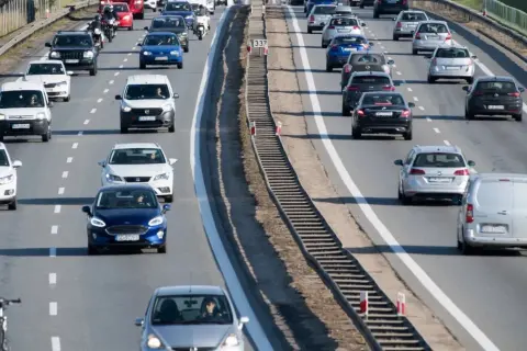 Ruch na drodze dwujezdniowej. Samochody osobowe i dostawcze jadą w korku.