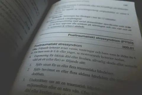 En boktext beskriver kriterier för posttraumatiskt stressyndrom (PTSD) och dess konsekvenser.