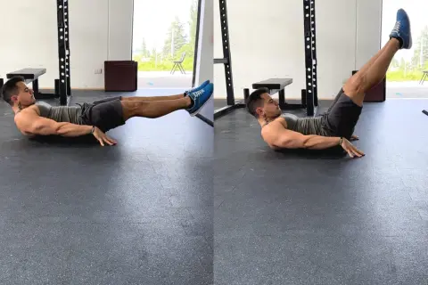 Uomo esegue crunch a gambe tese, uno dei migliori esercizi addominali per scolpire il core.
