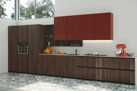 Modernos diseños de cocinas con gabinetes de madera oscura, encimeras blancas y gabinetes superiores rojos vibrantes. Una batidora roja y frutas añaden color.