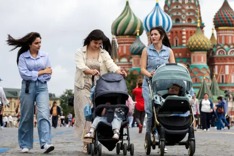 Kobiety z wózkami spacerują po Placu Czerwonym. Tłum ludzi, jak na obrazku, to tylko ułamek całej **rosja liczba ludności**.