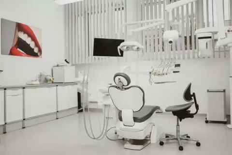 Nowoczesny gabinet stomatologiczny z fotelem dentystycznym i obrazem ust.