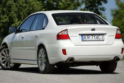 Biały Subaru Legacy z tablicą KR 716CJ.
