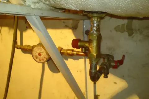 Zawór bezpieczeństwa w bojlerze, obok wodomierza, zapewnia ochronę instalacji.