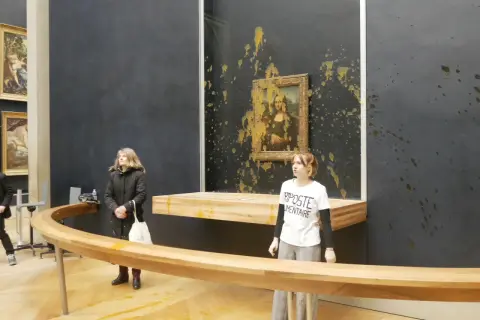 Obraz pokazuje, gdzie znajduje się Mona Lisa, w Luwrze, z żółtą substancją rozbryzganą na ścianie i obrazie.