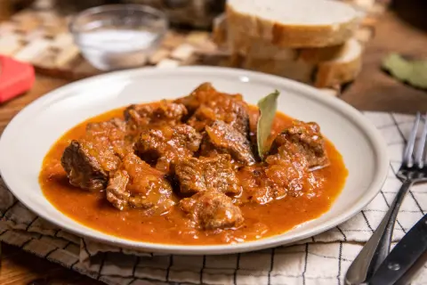 Sabrosa carne guisada con tomate, tiernos trozos de carne en una rica salsa, servida en un plato blanco.