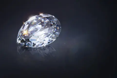 Błyszczący diament Cullinan, odbijający światło, na ciemnym tle.