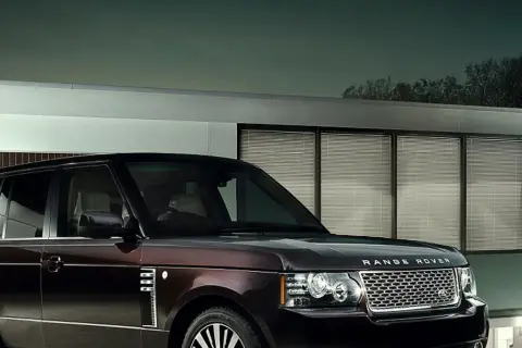 Elegancki Range Rover Autobiography w ciemnym kolorze lśni przed nowoczesnym budynkiem z przeszklonymi oknami.