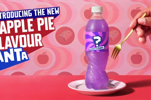 Fioletowa Fanta o smaku jabłecznika z etykietą znaku zapytania, obok widelca.