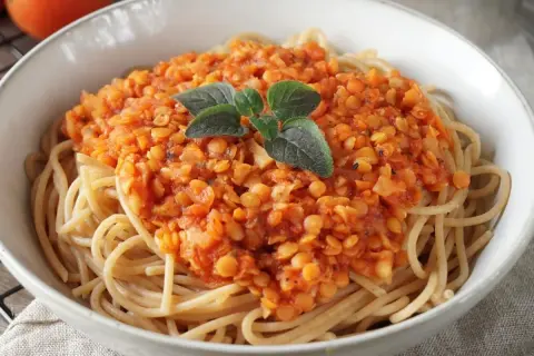 Herzhafte Linsen Bolognese auf Spaghetti, garniert mit frischen Kräutern. Ein köstliches vegetarisches Gericht.