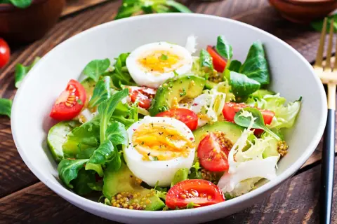 Frischer Salat mit Avocado, Tomaten und gekochten Eiern – perfekt für eine leichte Mahlzeit zum Abnehmen.