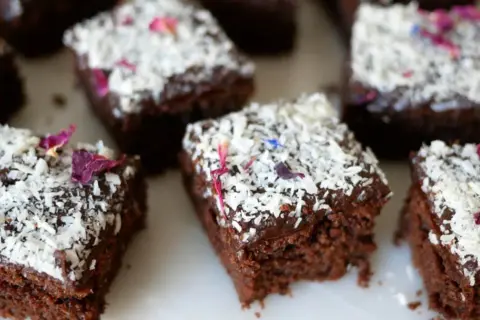 Små bitar av saftiga kärleksmums utan mjölk, toppade med chokladglasyr, kokosflingor och vackra blomblad.