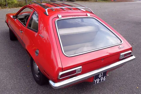 Czerwony Ford Pinto Runabout z bagażnikiem dachowym, gotowy na przygodę.