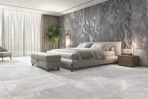 Dormitorio moderno con suelo de porcelánico rectificado, cama confortable y pared decorativa con diseño abstracto.