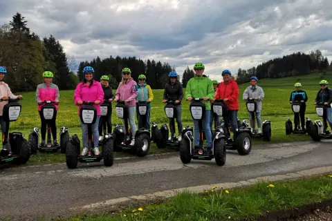 Eine Gruppe von Menschen steht auf Segways, die eine einfache Art der Fortbewegung darstellen.