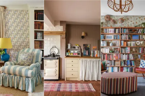 A cozy modern English cottage interior with a striped armchair, a vintage stove, and a wall of books.