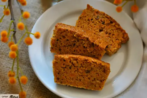 Rebanadas de bizcocho de zanahoria casero, esponjoso y con trocitos de zanahoria visibles, servidas en un plato blanco.
