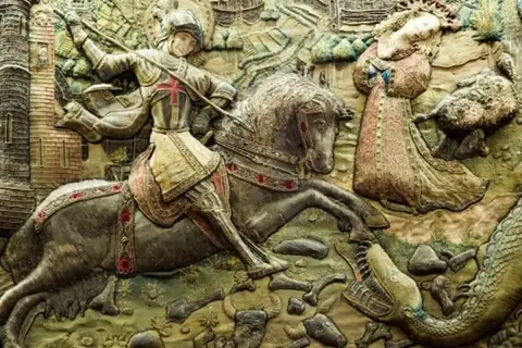 Relieve de San Jorge luchando contra el dragón, con la princesa a salvo. Una escena épica de España.