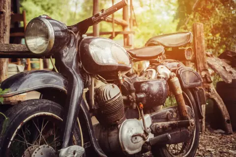 Detalle de una moto antigua, lista para restaurar. Su motor y chasis muestran el paso del tiempo, esperando una nueva vida.