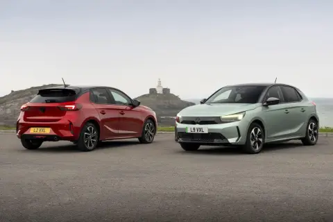 Dwa nowe modele Vauxhall Corsa, czerwony i zielony, stoją na tle morza i latarni morskiej.