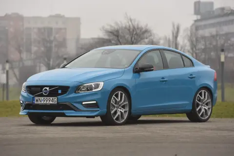 Błękitne Volvo S60 na tle budynków. Poznaj jego wymiary i możliwości.