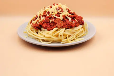 Pyszne spaghetti z sosem bolońskim i startym serem. Idealne danie, gdy zastanawiasz się, jak zrobić spaghetti.