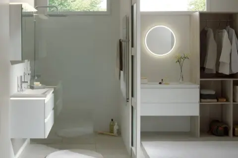 Salle de bain moderne avec douche, meuble vasque, miroir lumineux et dressing ouvert.