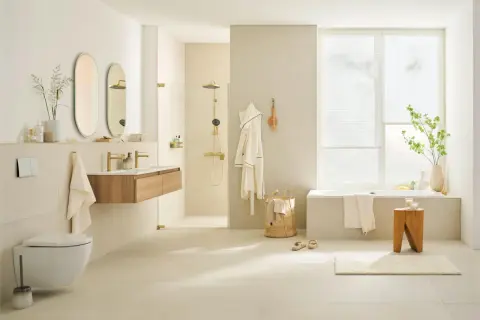 Modernes badezimmer braun creme mit freistehender Badewanne, Dusche, Waschtisch und Hänge-WC. Helle Fliesen und Holzakzente schaffen eine warme Atmosphäre.